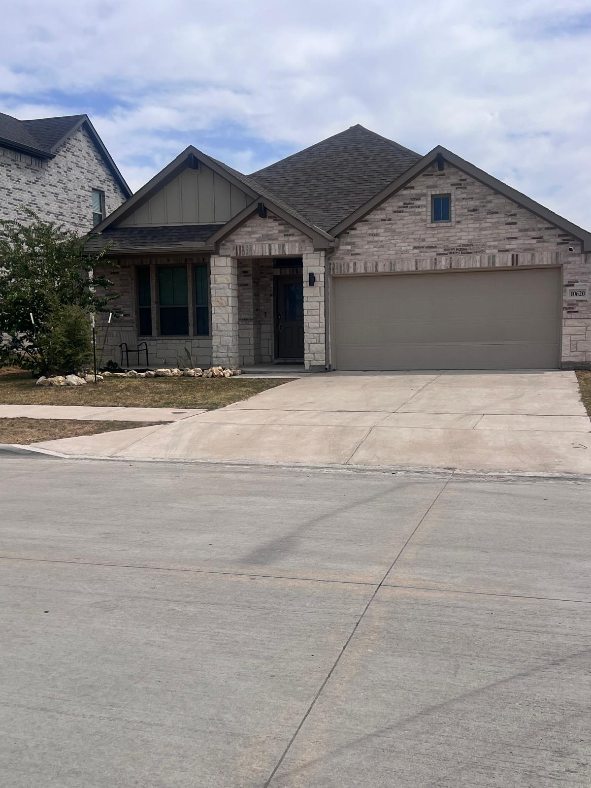 Single-story brick and stone home with a two-car garage and covered front porch